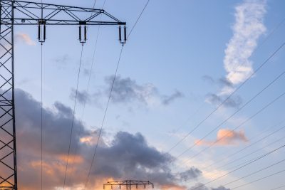 Clouds and power lines. High voltage infrastructure. Electricity in nature