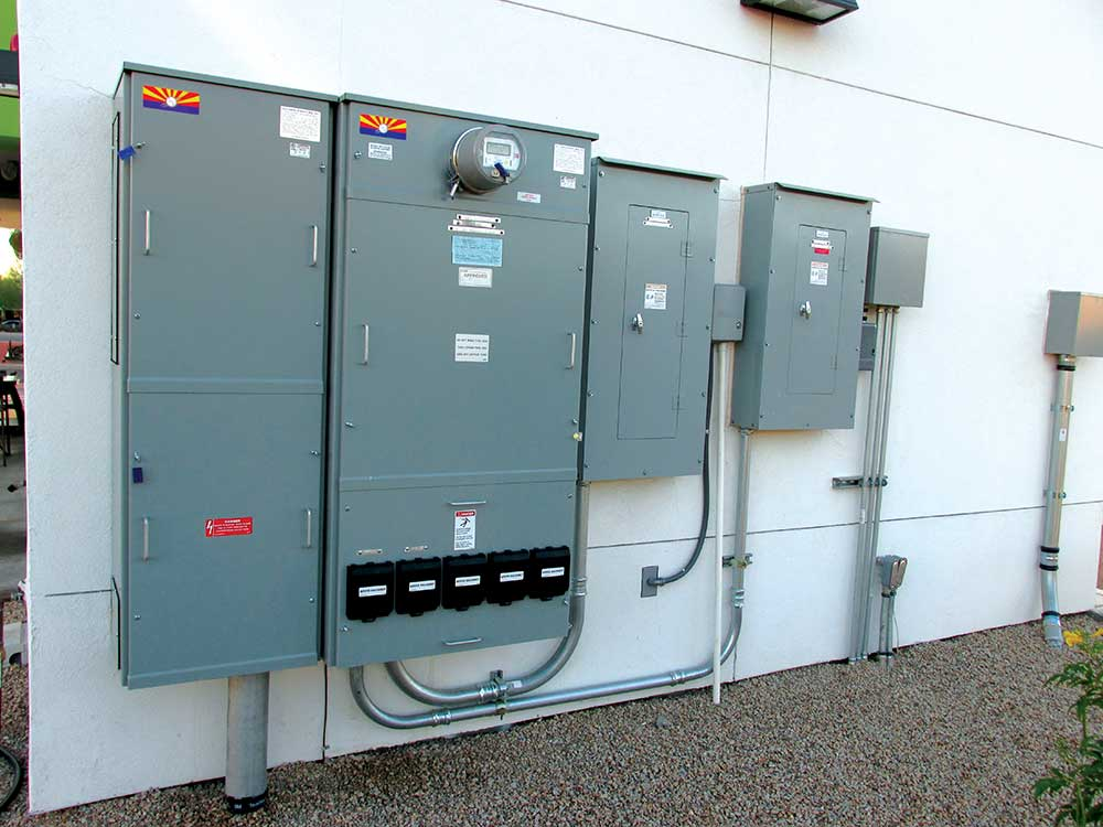 Commercial electrical service panels and molded case breaker enclosures mounted on an exterior building wall  