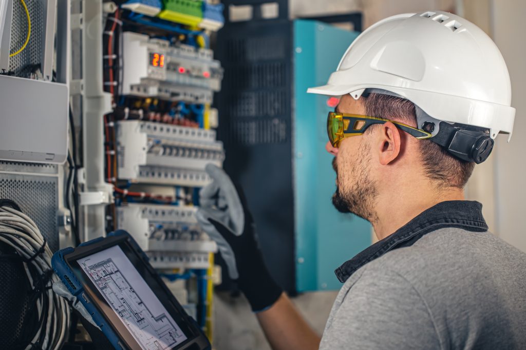 man electrica technician working switchboard with MCCBs